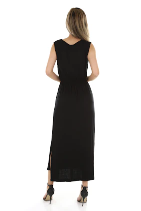 A stylish woman wearing a sleek black dresply dress standing against a minimalist white background
