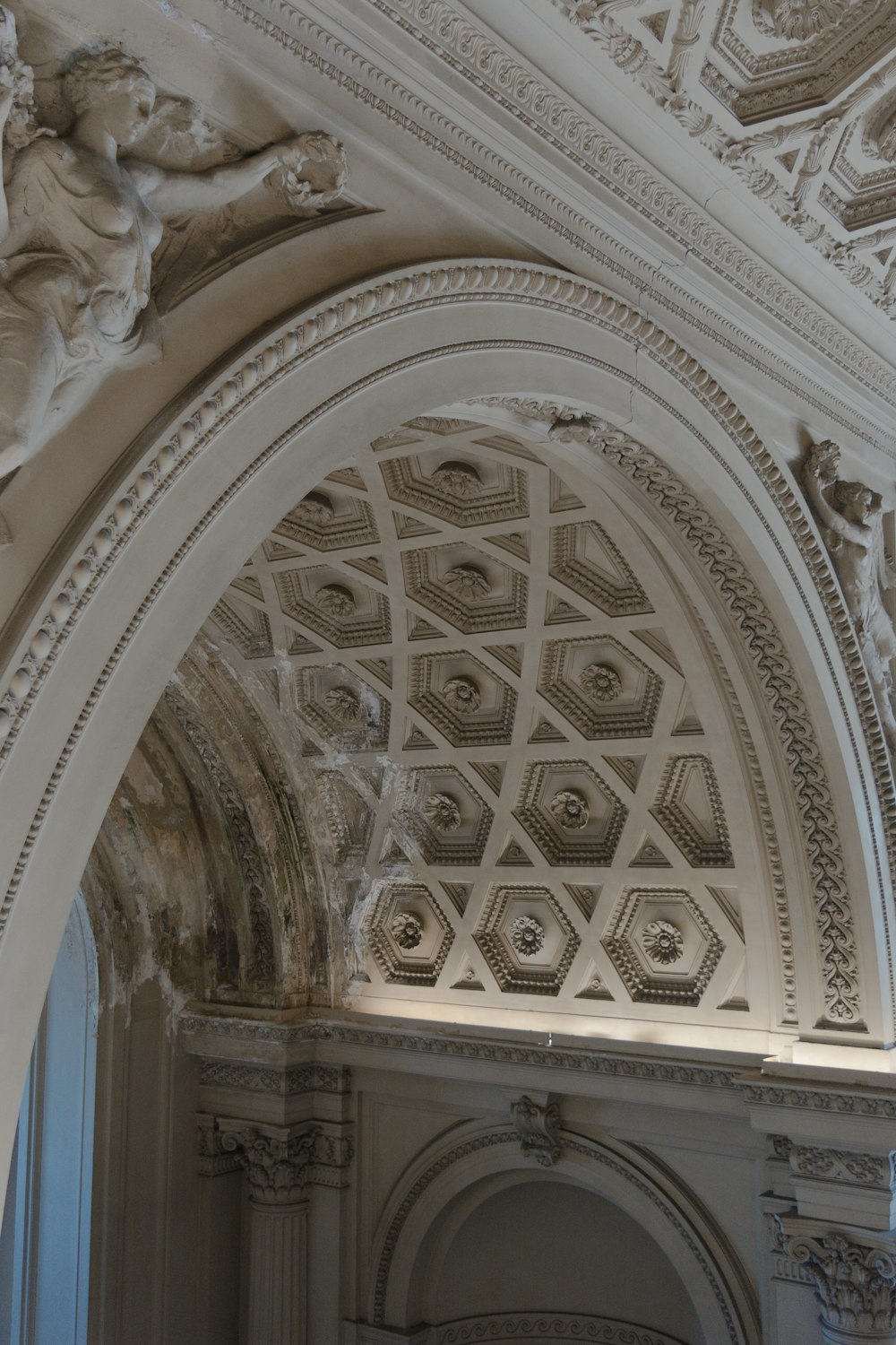 the ceiling of a building with a statue on it