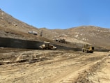 Heavy machinery operating on a construction site against a desert backdrop.