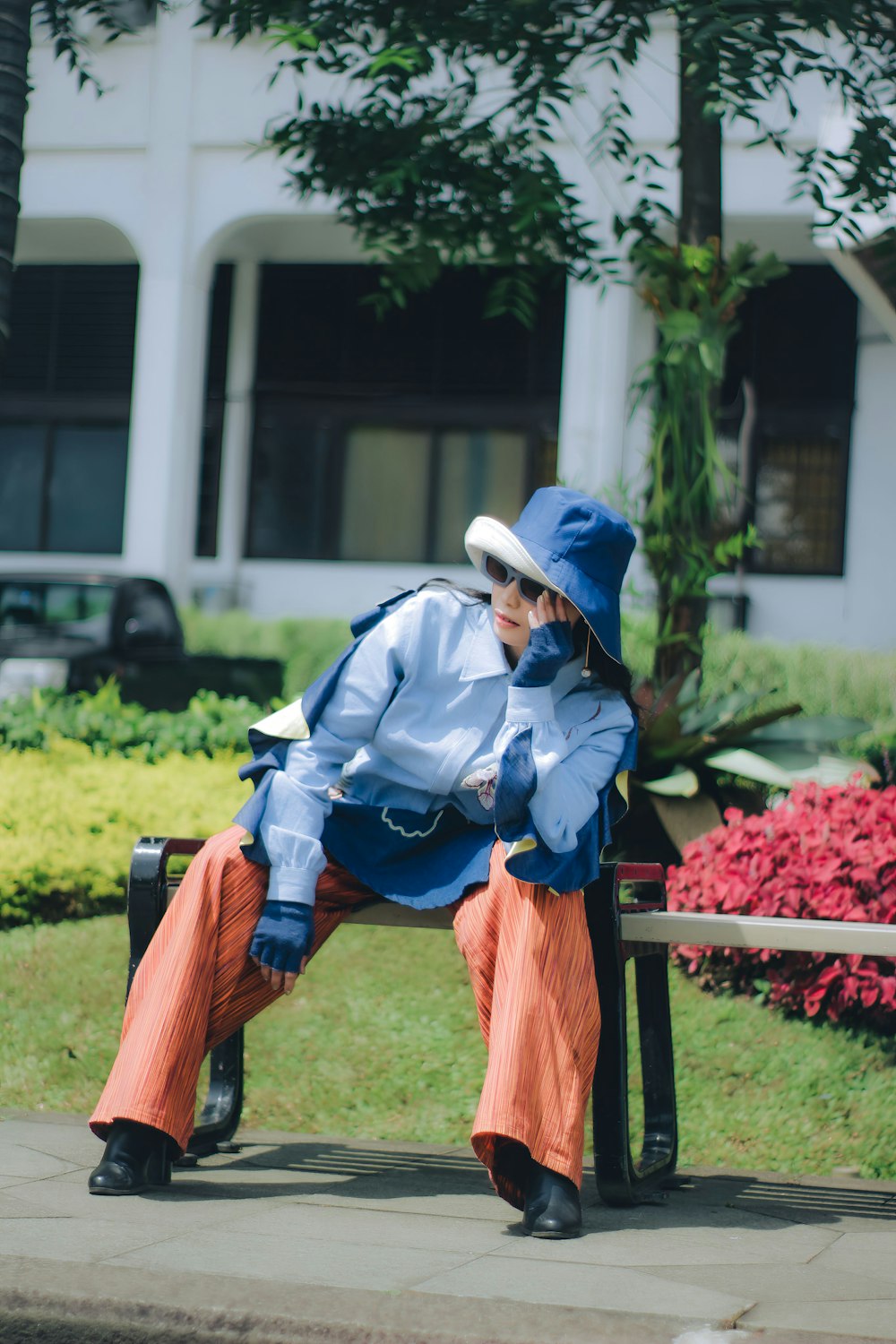 a person sitting on a bench wearing a blue hat