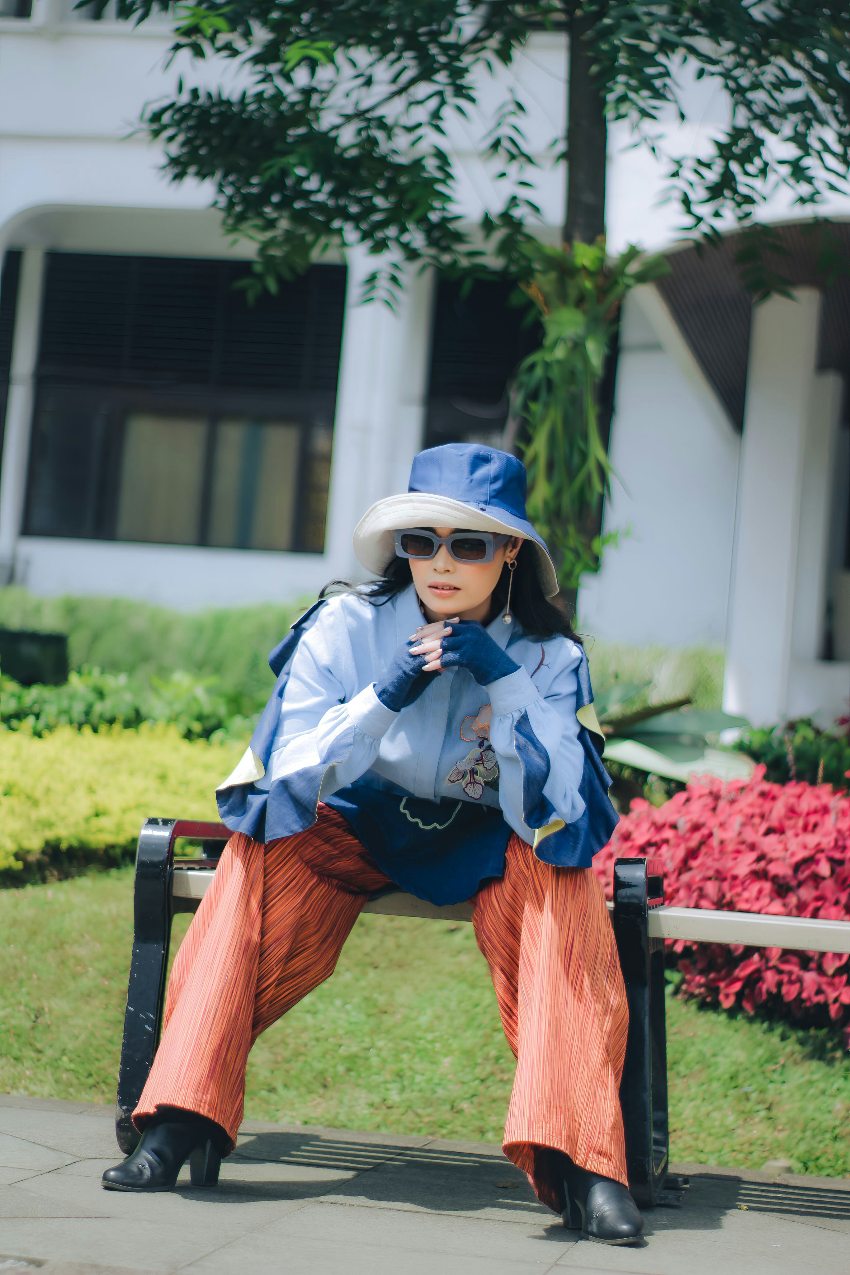seorang wanita duduk di bangku di depan sebuah gedung