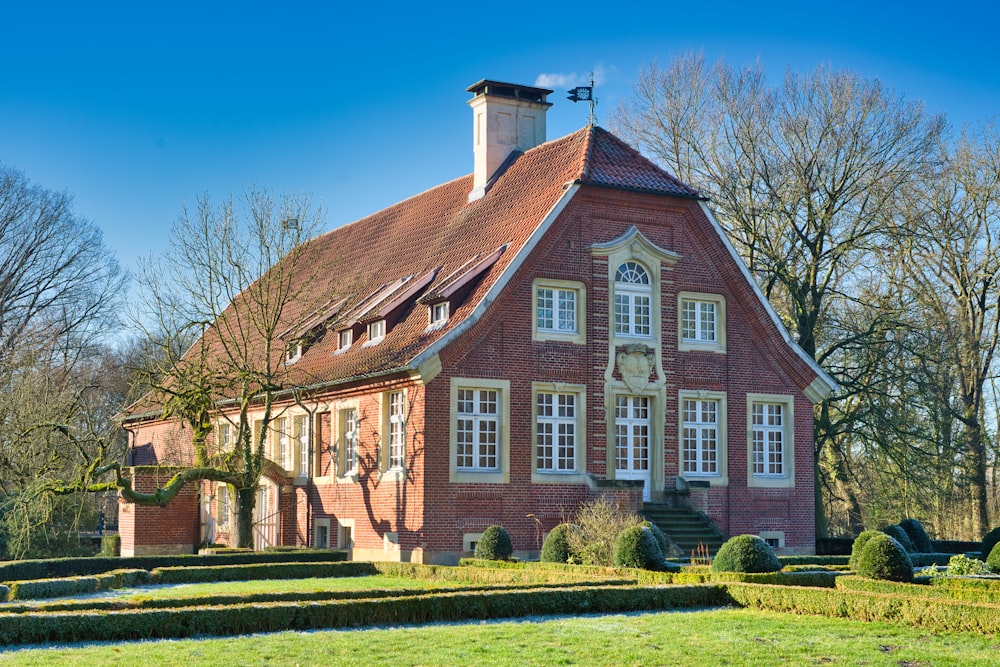 a red brick house with a garden in front of it