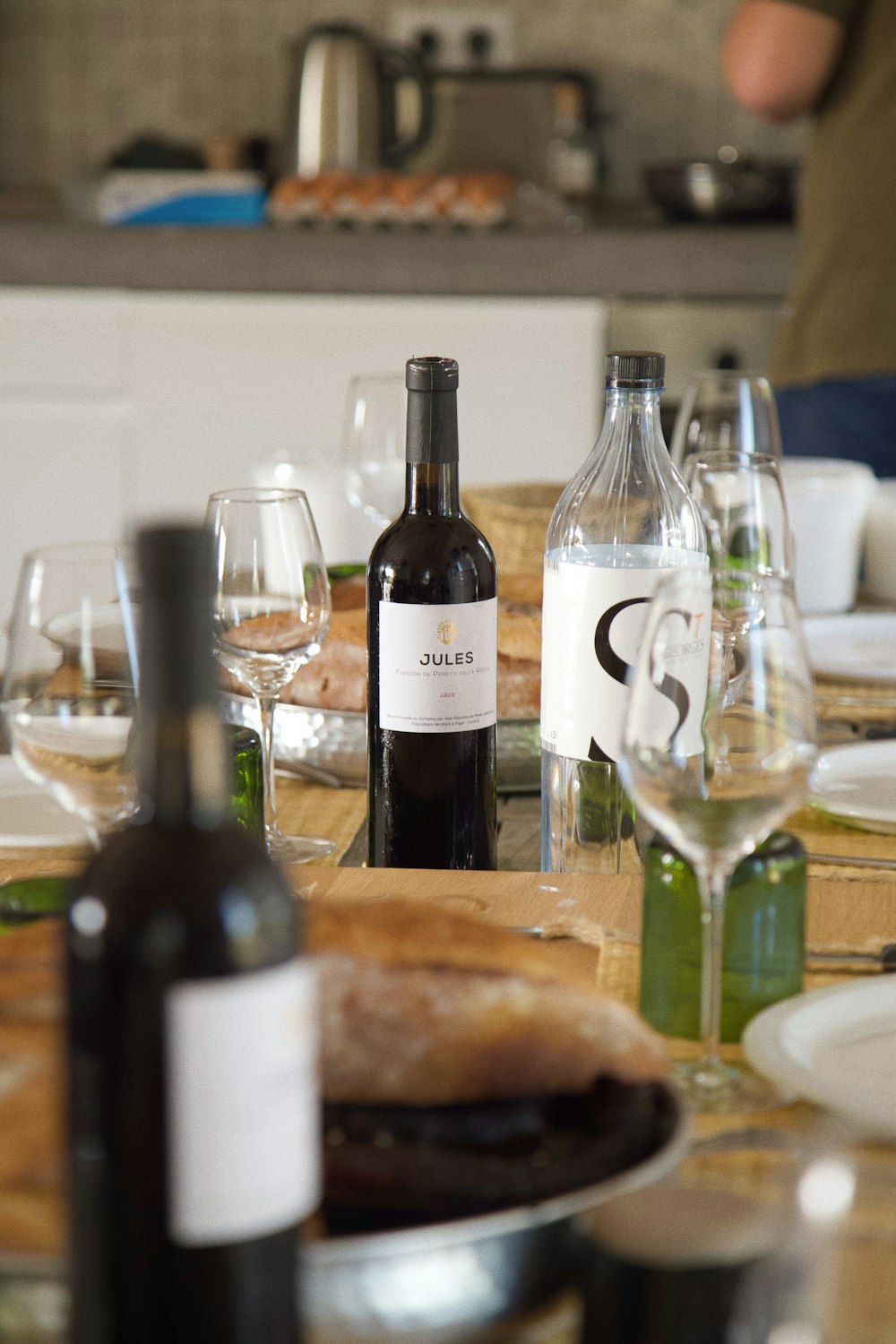 a table with a bottle of wine and a plate of food