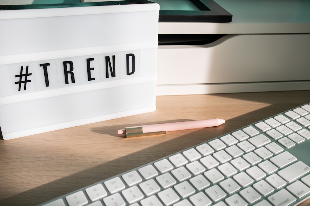 a keyboard and a pen sitting on a desk