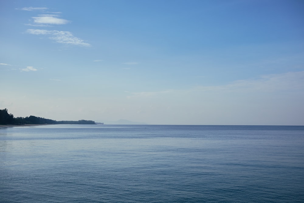 a large body of water sitting under a blue sky