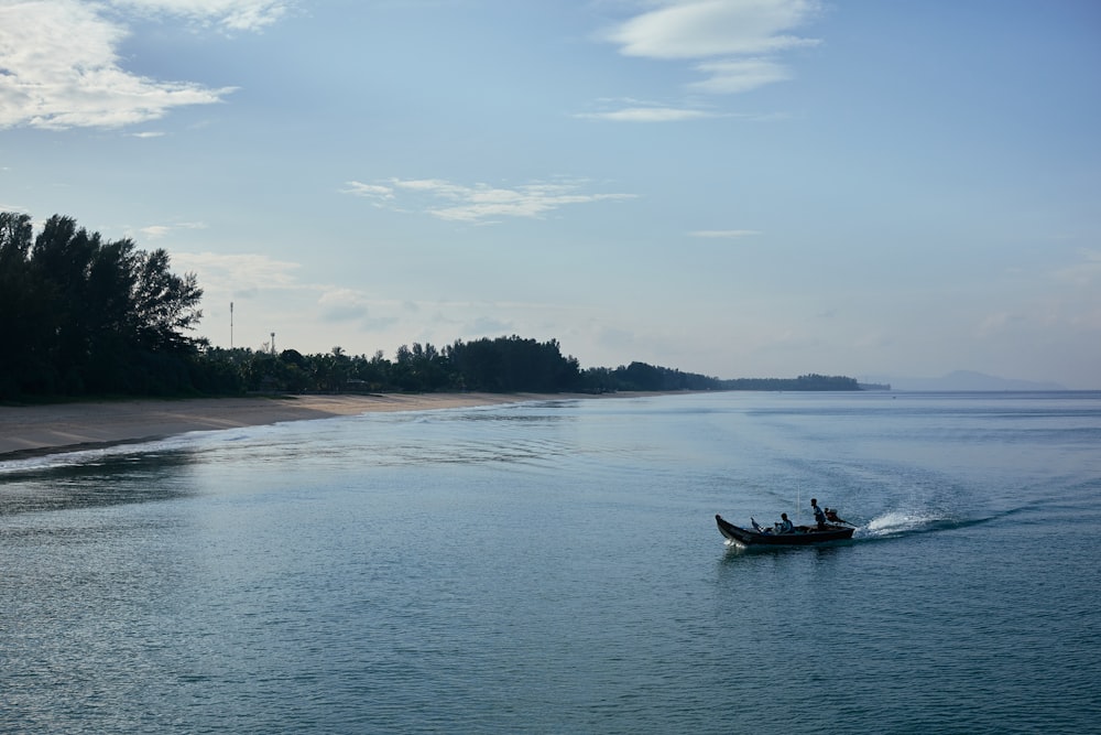 a small boat traveling down a river next to a beach