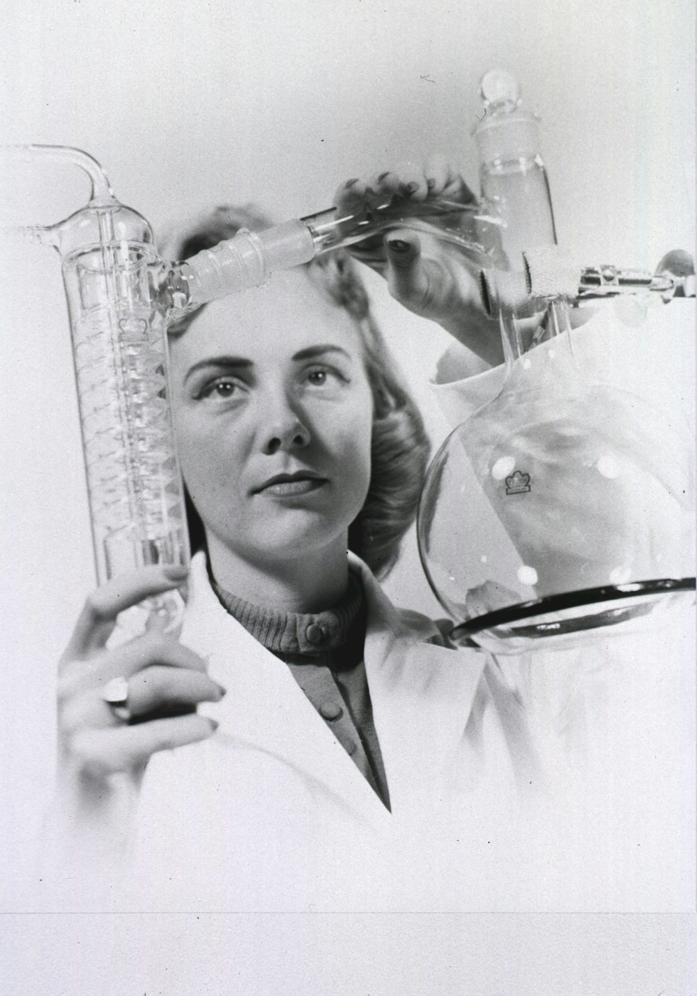 a black and white photo of a woman holding a flask