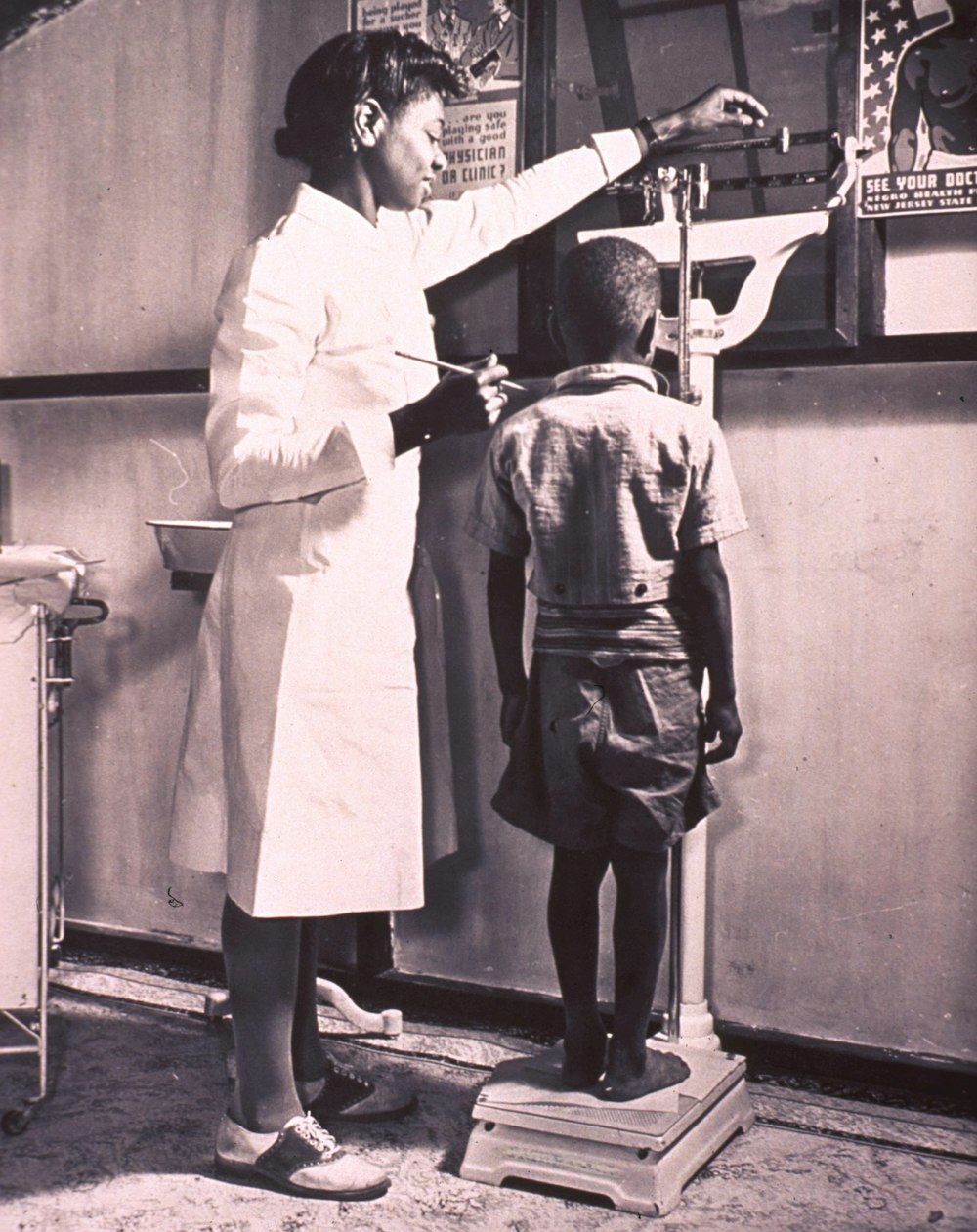 a woman in a white coat and a boy in a black and white photo