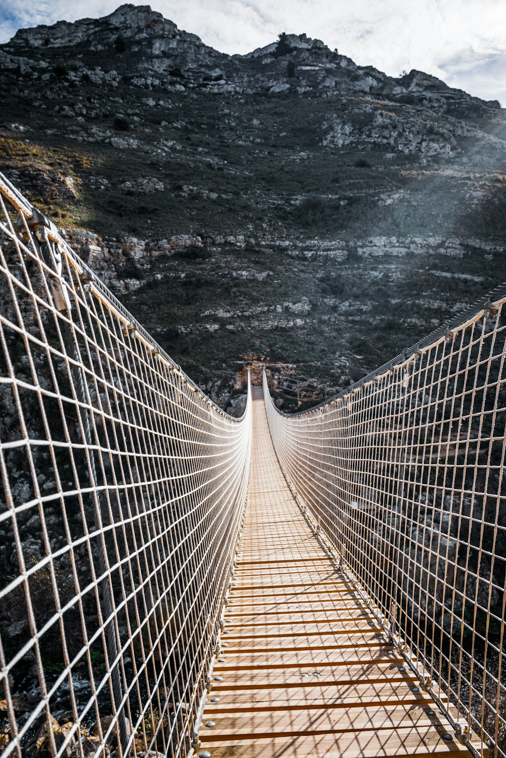 a wooden walkway with a wire fence on top of it