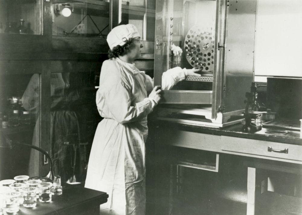 a black and white photo of a woman in a lab