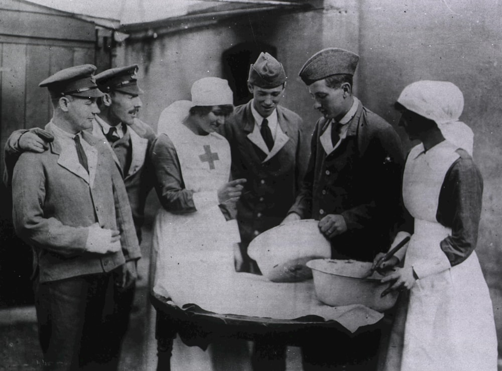 a group of men and women standing around a table