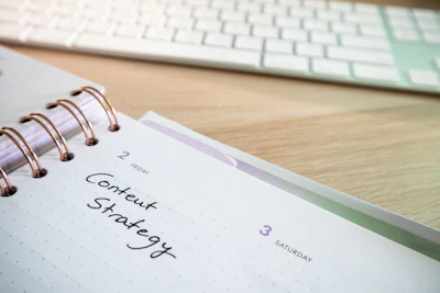 a notepad with a spiral - bound notebook on it next to a keyboard