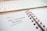A close-up of a spiral-bound notebook open to a page with 'User-Generated Content' written on it in black ink. The page indicates it's Tuesday, the 22nd, and the notebook lies on a desk beside a white computer keyboard.