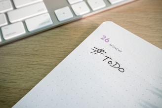 a close up of a notepad with a keyboard in the background
