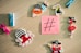 A collection of colorful cartoon-themed magnets and clothespins arranged on a wooden surface around a sticky note with a large hashtag symbol. The magnets include pirate-themed animals and characters like an octopus and birds wearing pirate hats.