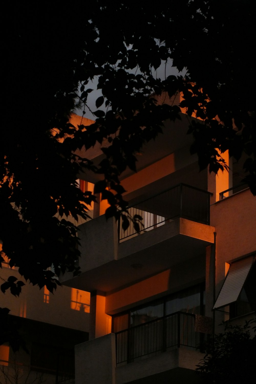 a tall building with a balcony and balconies lit up at night
