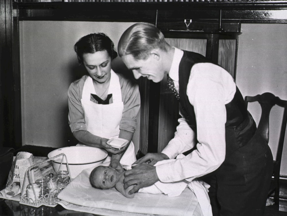 a man and a woman are preparing a baby