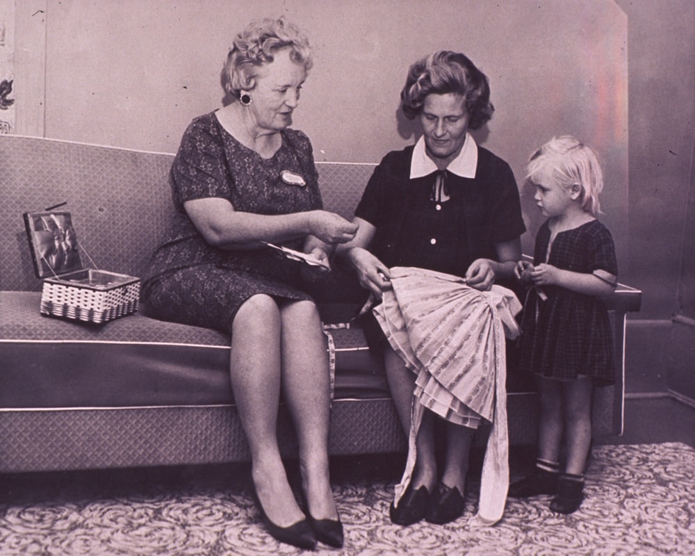 a woman and two children sitting on a couch