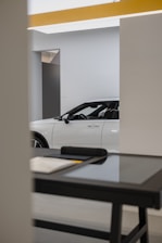 a white car is parked in a showroom