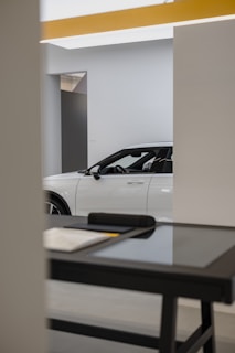 a white car is parked in a showroom