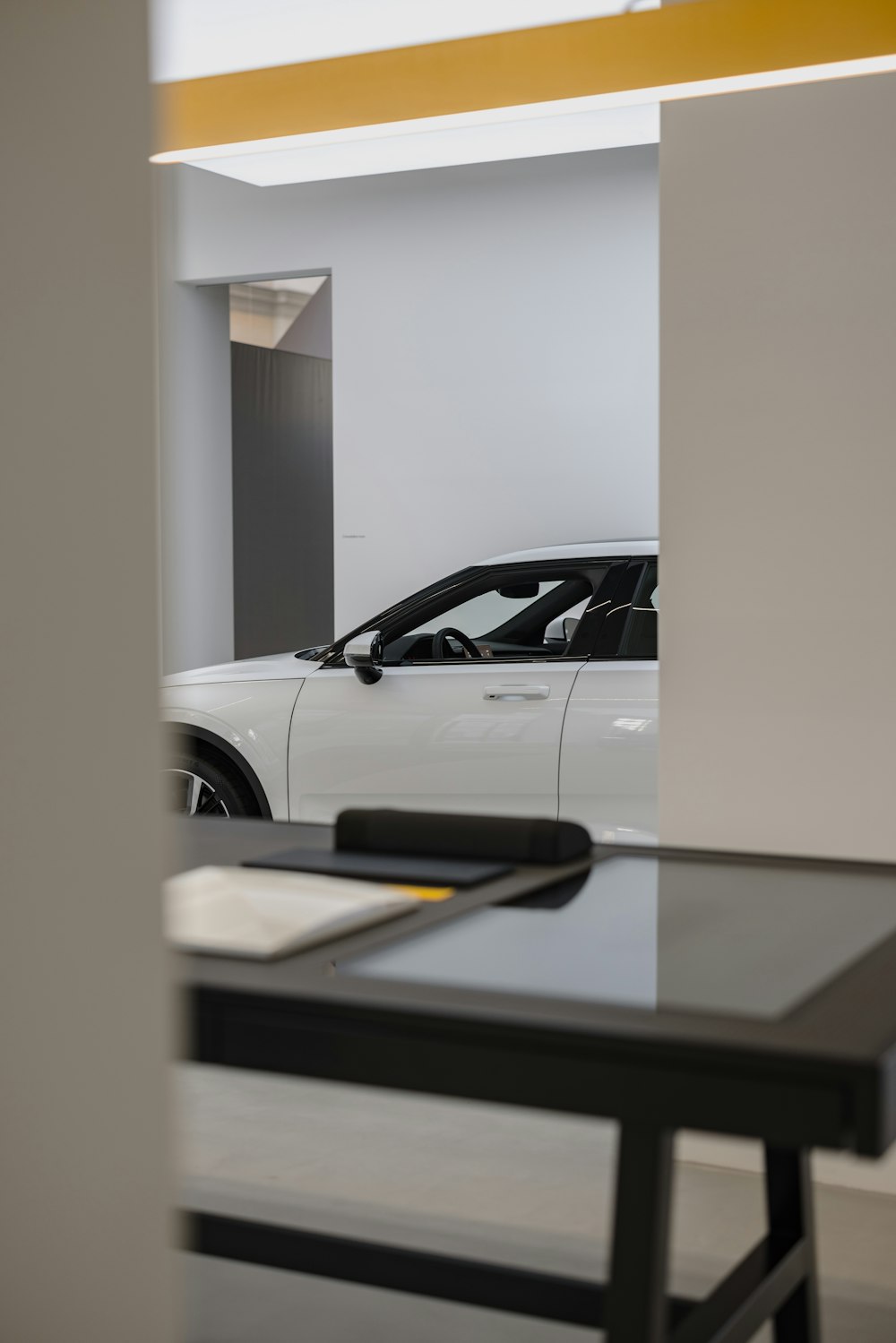 a white car is parked in a showroom