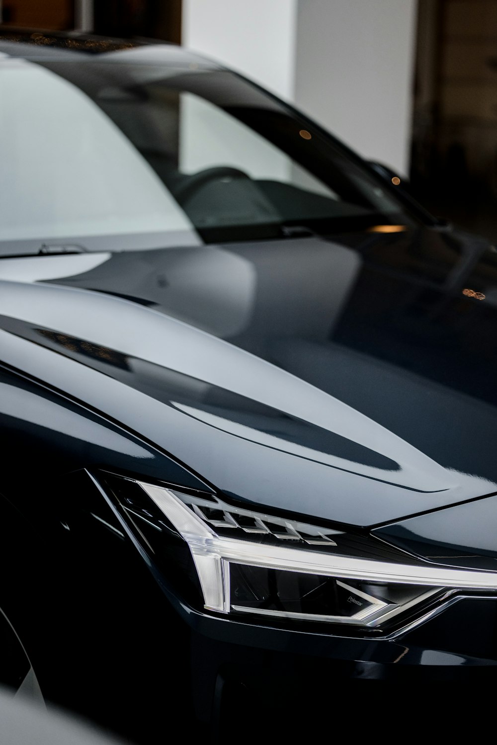 a close up of a black car parked in a garage