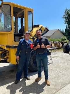 Smiling customer shaking hands with a Solid Stone Solutions worker beside a completed concrete patio.