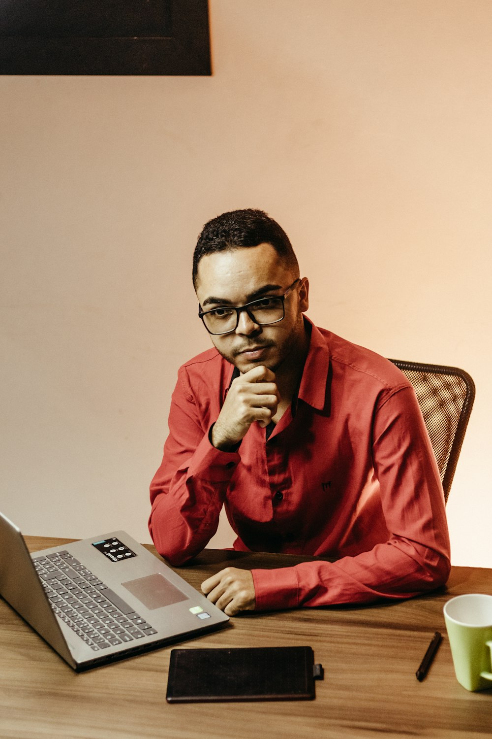 a man sitting at a table with a laptop in front of him