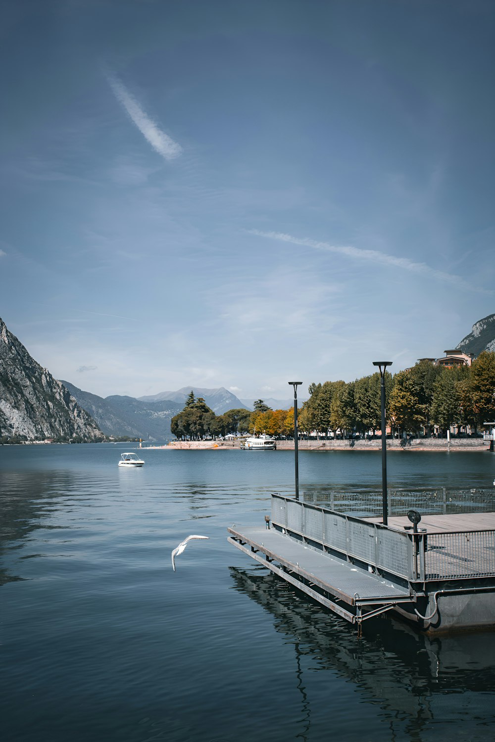 a boat floating on top of a lake next to a pier