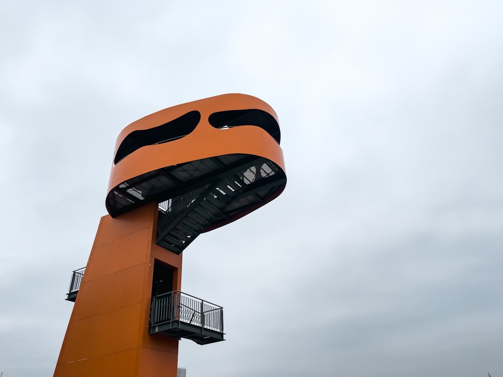 a tall orange structure with a spiral staircase