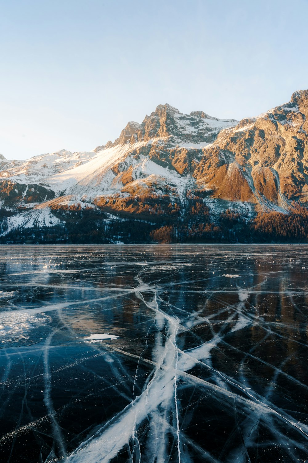 a frozen lake with mountains in the background