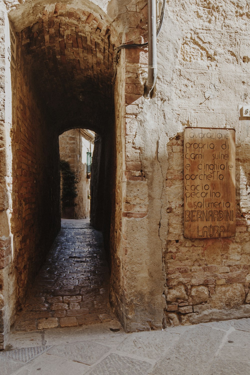 a narrow alley way with a sign on the side of it