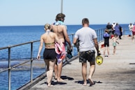 A group of smiling adventurers gearing up for a snorkeling excursion on a sunny beach.