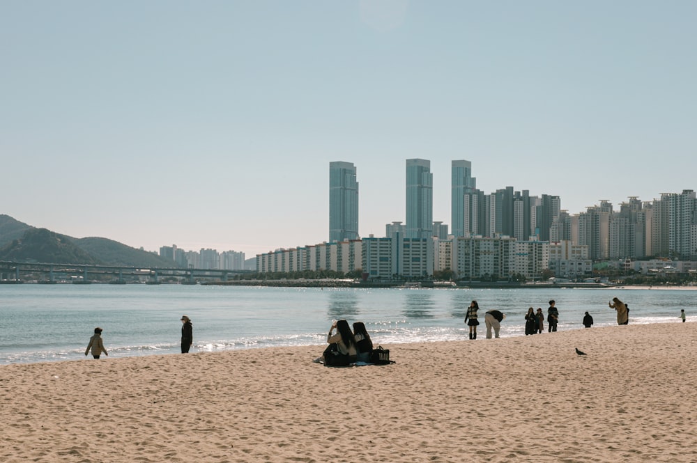 a group of people standing on top of a sandy beach