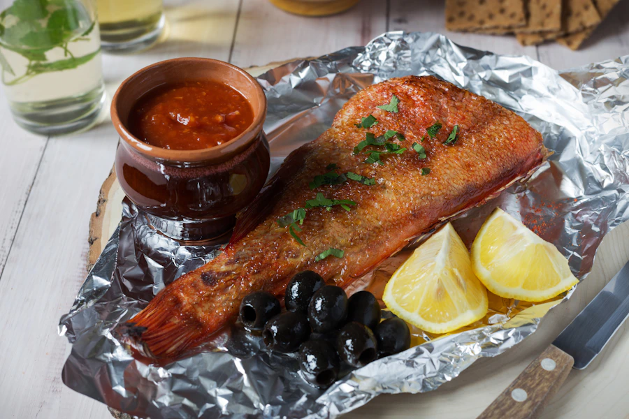 Peixe assado no forno com limão, ervas, azeitonas e tomate