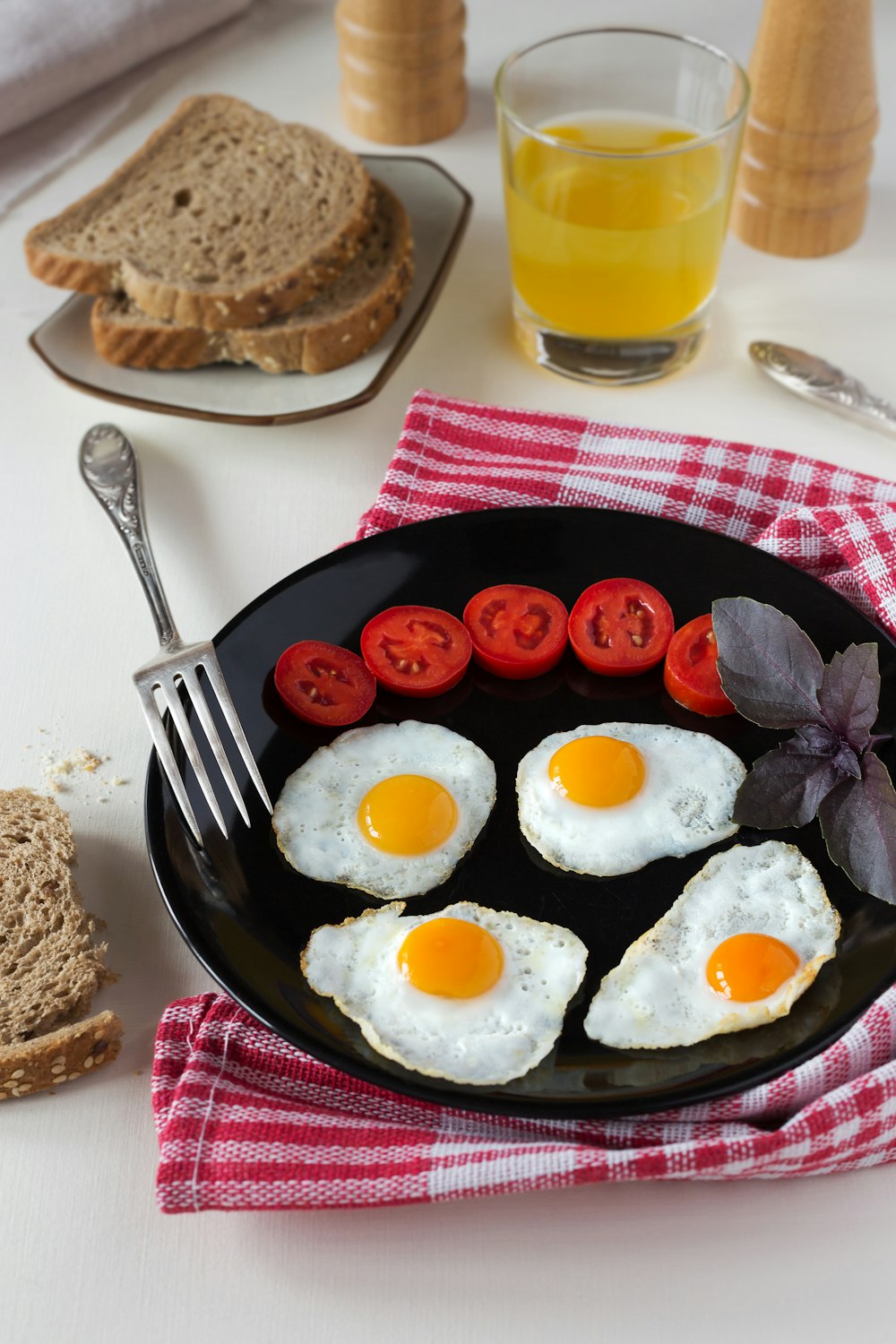 a plate of eggs, tomatoes and toast on a table