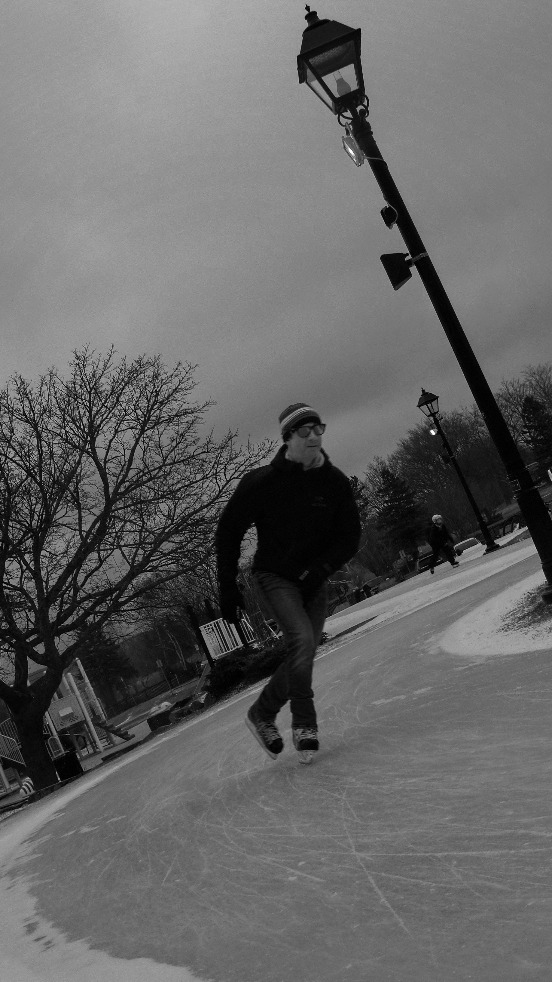 A man skating on an ice rink under a street light photo – Free St. john ...