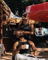 A man and a woman laughing together at a café terrace.