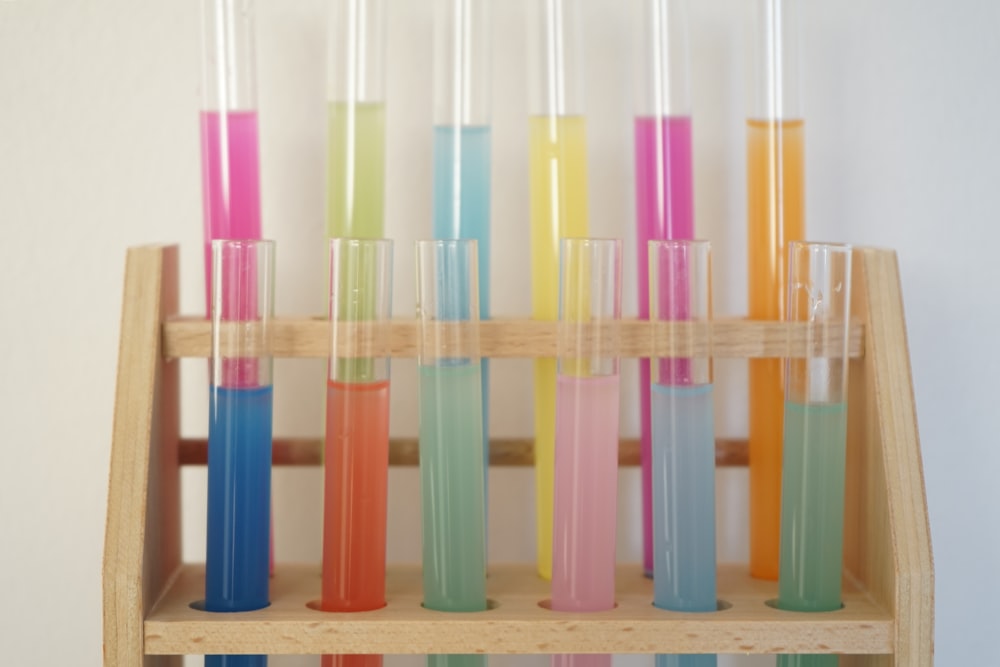 a wooden shelf filled with different colored liquids