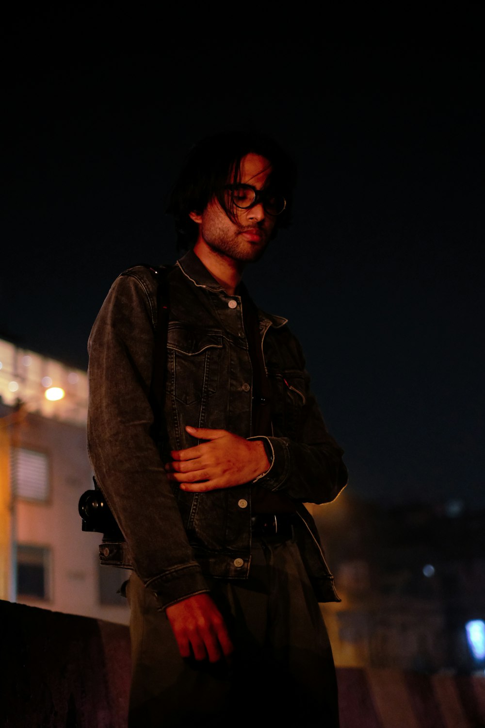 a man standing in front of a building at night