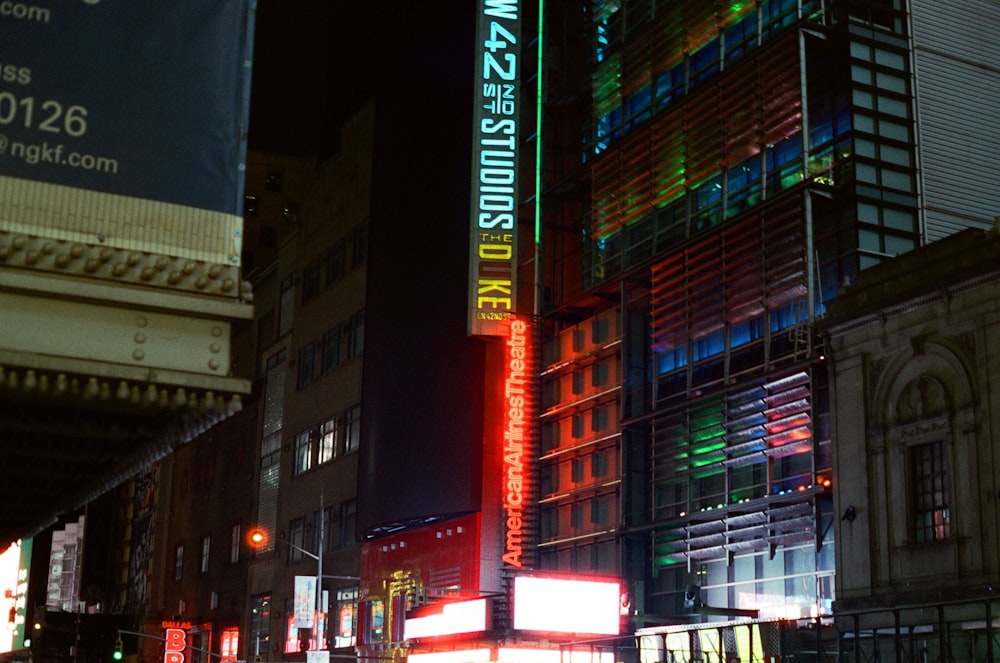 a city street at night with a neon sign