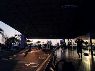 A busy airport terminal with travelers and airplanes visible outside.