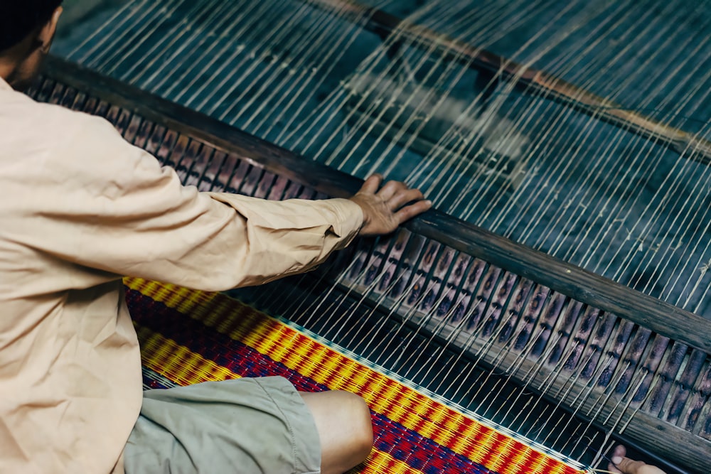 a man is weaving fabric on a loom