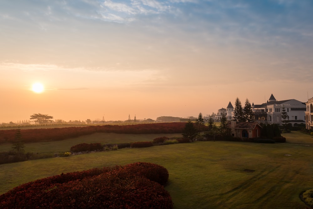 the sun is setting over a large house