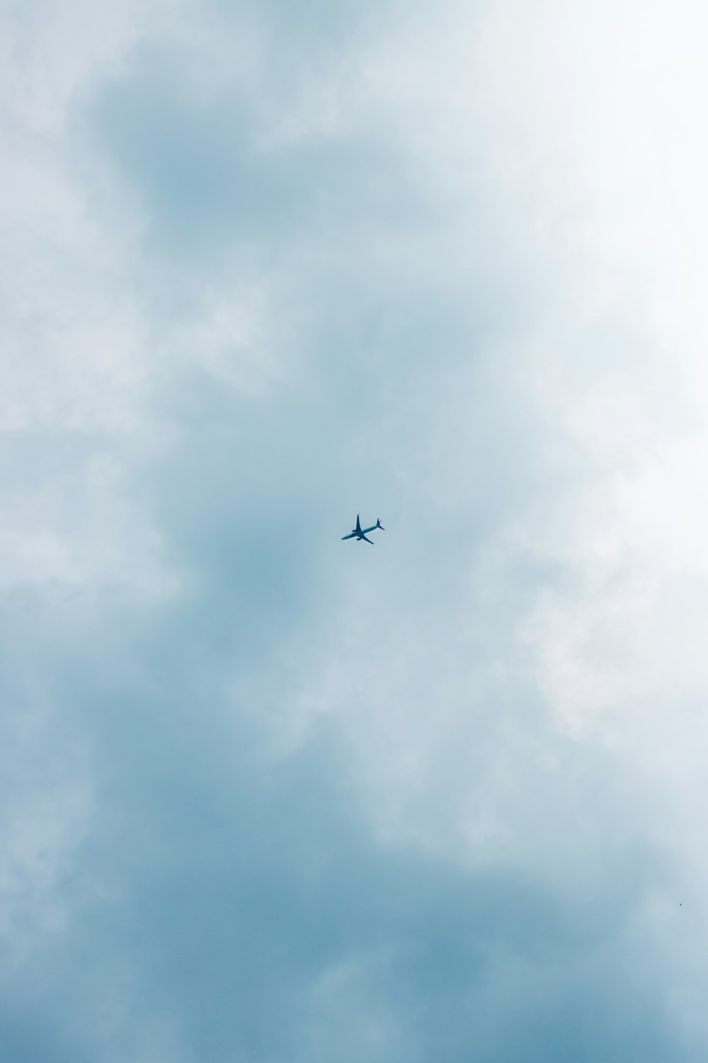 an airplane is flying in the sky on a cloudy day