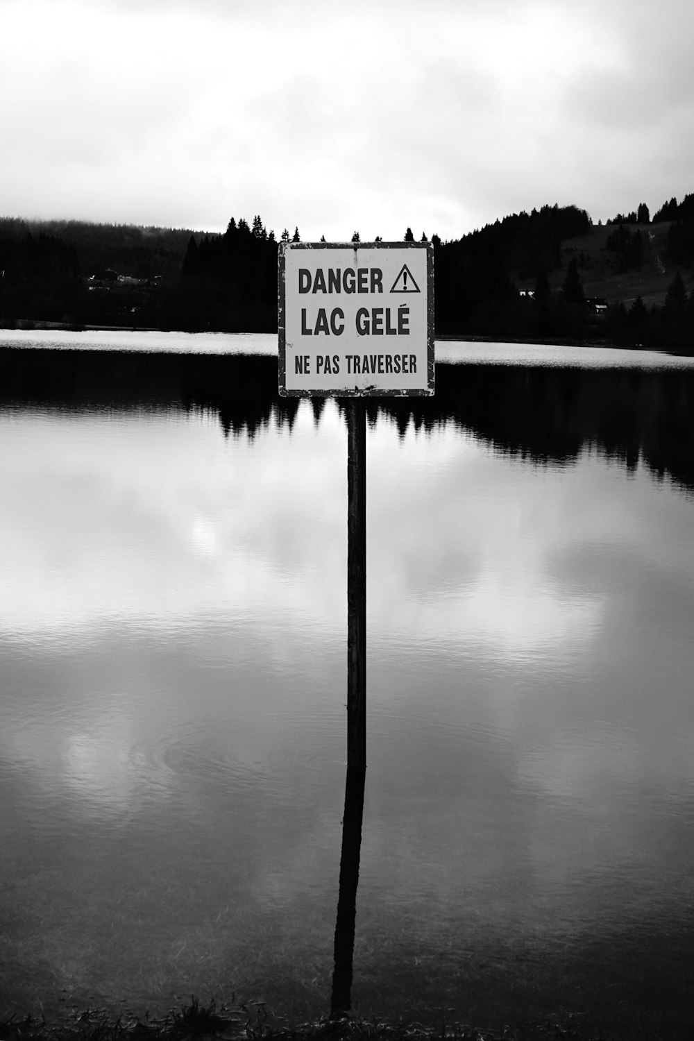 a sign that is on a pole in the water