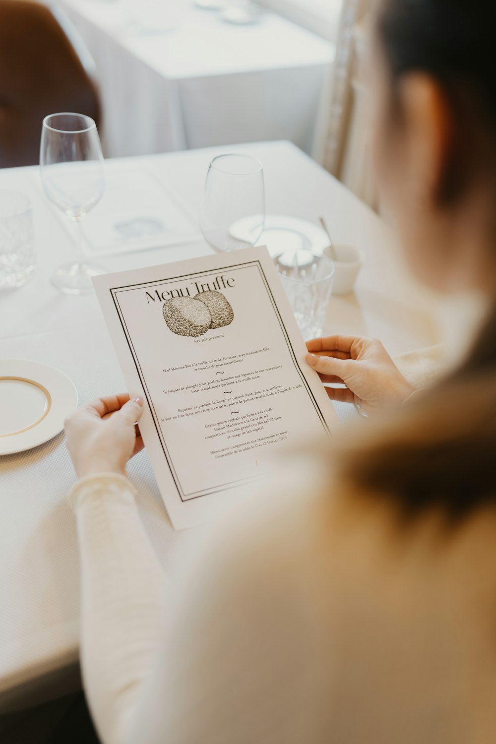 a woman sitting at a table with a menu