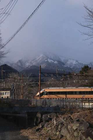 A sleek, modern train gliding through misty mountains at dawn.