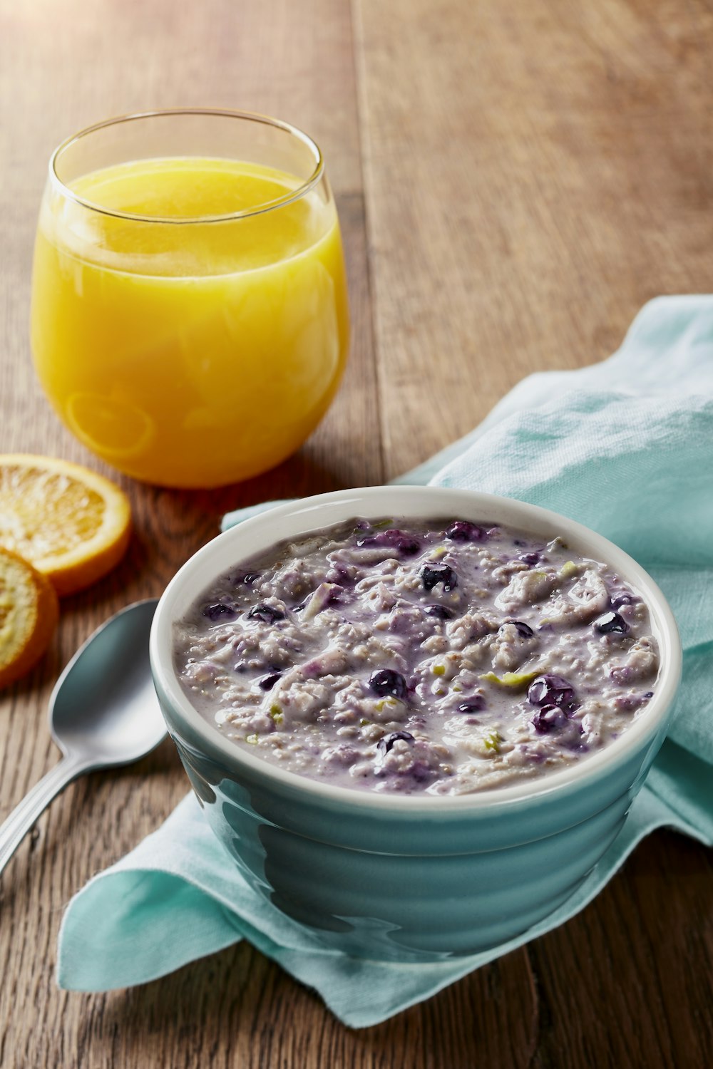 a bowl of oatmeal next to a glass of orange juice