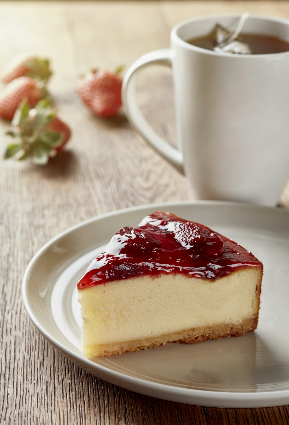 a piece of cheesecake on a plate next to a cup of coffee